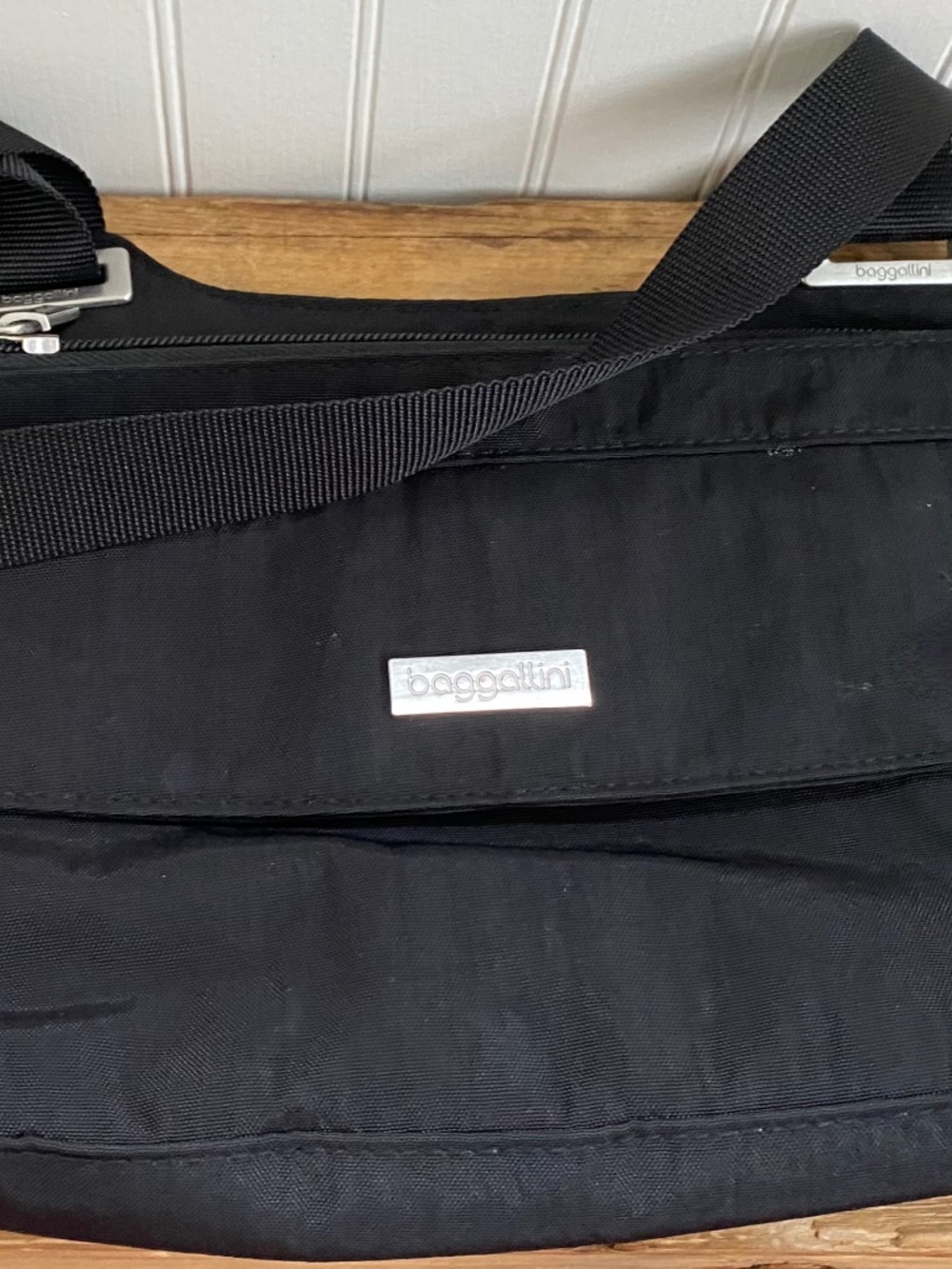 Black Nylon Baggallini Bag with Shoulder Strap and Front Clasp. Zipper Opening.